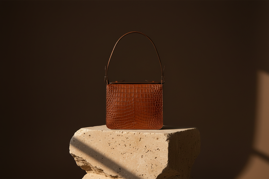 Editorial NOWA CROC — CAMEL handbag on a sculptural limestone pedestal